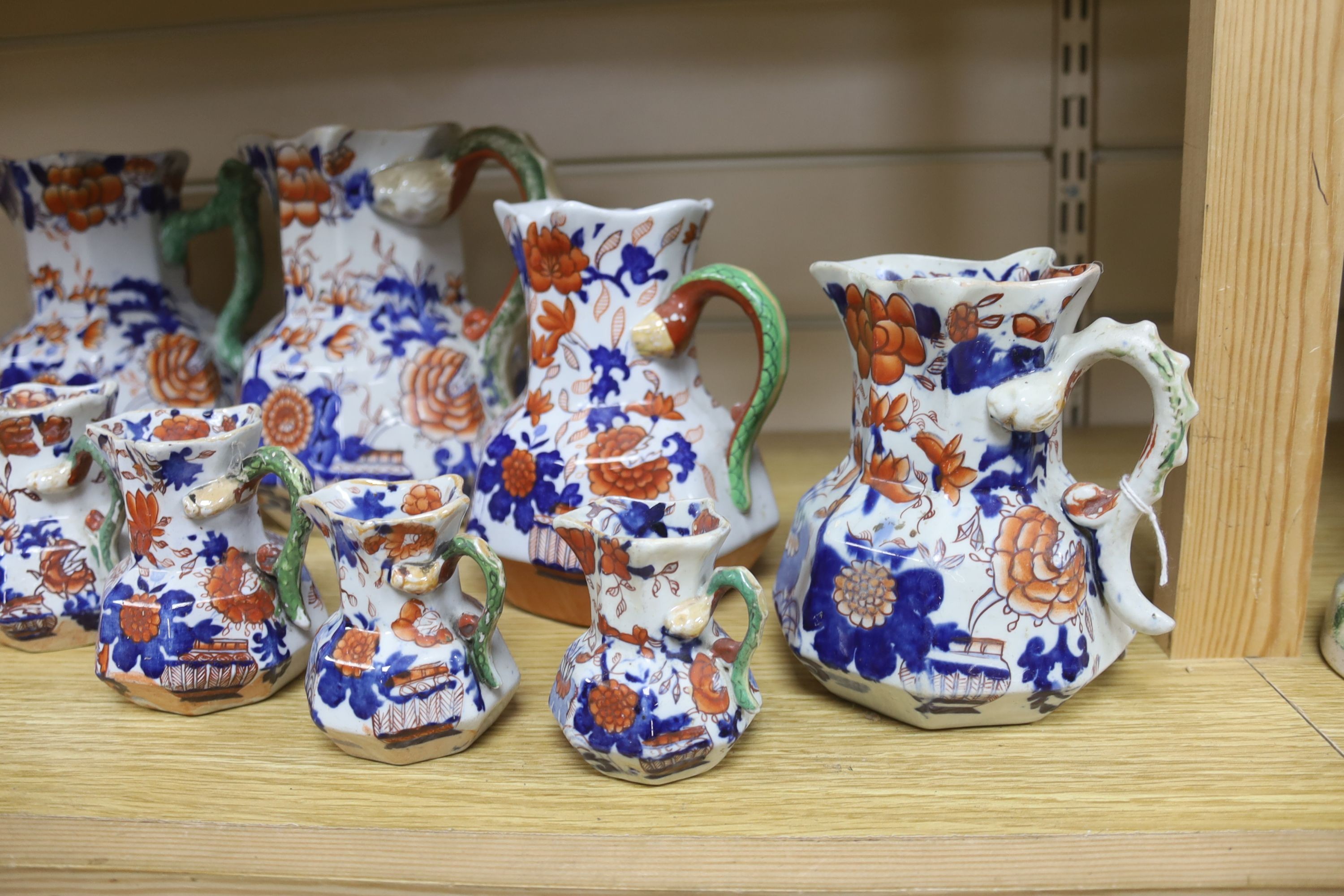 A graduated set of eight Mason's floral Imari pattern ironstone hydra jugs, c.1820-30, largest 19cm smallest 7cm and two other Mason’s ironstone jugs (10)